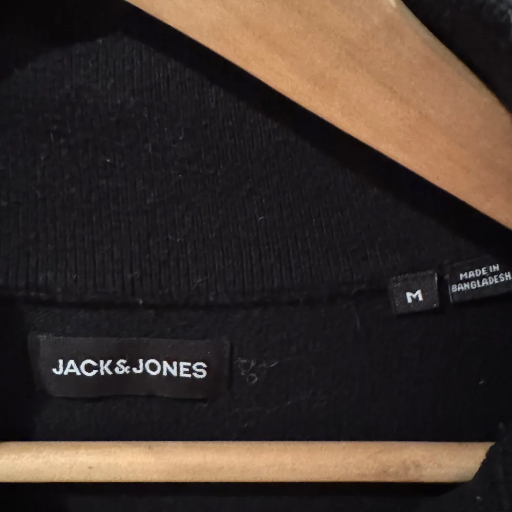 Säljer en stilren svart tröja från Jack & Jones i storlek M. Tröjan har en praktisk dragkedja framtill och är perfekt för både vardag och fest. Den är i bra skick och passar till alla tillfällen. Perfekt för höst och vår!. Tröjor & Koftor.