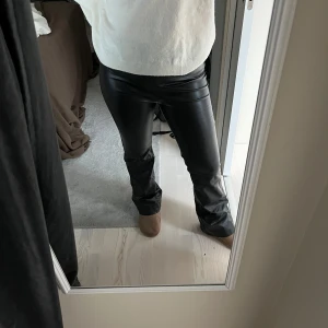 Svarta skinnbyxor - Säljer ett par snygga svarta skinnbyxor i mycket bra skick. De är bootcute och Midwaist men går även att vika ner så de blir lågmidjade 