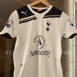 Tottenham Hotspur Fotbollströja - Säljer en Tottenham fotbollströja  med korta ärmar och snygga svarta detaljer. Tröjan har 'Bale 3' på baksidan. 