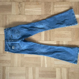 Blåa Lois Jeans, Raval - Säljer ett par såå snygga blå Lois jeans i mycket bra skick. De är i den populära modellen Raval, som är deras bootcut modell! Byxorna är lite stretchiga, nypris 1800kr, Storlek w 27 l34.  Midjemått: 73cm innerbenslängd: 86cm