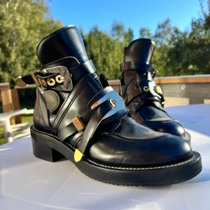 Svarta boots från Balenciaga - Säljer ett par svarta Balenciaga boots i skinn med coola gulddetaljer och spännen. De har en robust klack och ser riktigt lyxiga ut. Perfekta för höst och vinter, och de är i mycket bra skick. Passar både till vardags och fest! Skickar ENBART med Postnord, sökbart, och det är köparen som betalar frakten. 
