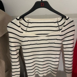 Randig ribbad tröja - Säljer en superfin vit och svart randig tröja med ribbad struktur. Den har en fyrkantig halsringning och långa ärmar, perfekt för både vardag och fest. Tröjan är i mycket bra skick och passar perfekt till höst- och våroutfits. Skicka ett meddelande vid intresse!