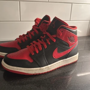Nike Air Jordans i svart och rött - Säljer ett par klassiska Nike Air Jordans i svart och rött. Skorna har en snygg design med röd snörning och den ikoniska swoosh-loggan på sidan. De är nytt skick. Säljer dom pga att dom ej kommer till användning längre. Använt ett fåtal gånger. Dom är lite små i storleken så passar även st 39-40. Box tillkommer!