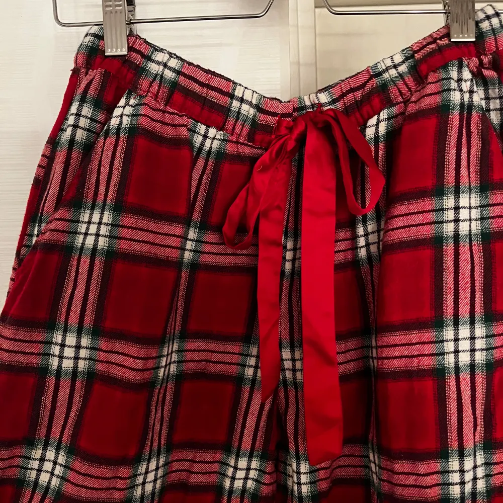 Mysiga röda rutiga byxor från Hunkemöller i storlek S. Perfekta som mysbyxor eller pyjamasbyxor. De har en bekväm passform med elastisk midja och ett snyggt knytband framtill. De är perfekta nu till julen!🥰🎅. Farkut & Housut.
