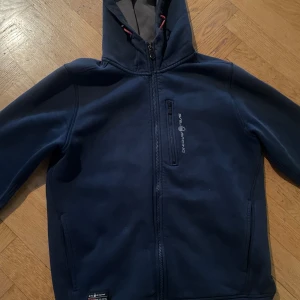 Mörkblå hoodie från Sail Racing - Säljer en mörkblå fleecejacka från Sail Racing i bra skick. 