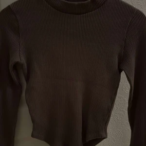 Brun ribbad tröja - Säljer en snygg brun ribbad tröja med långa ärmar. Perfekt för höst och vinter, den är både stilren och bekväm.