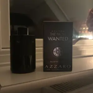 Säljer en flaska Azzaro The Most Wanted Eau de Parfum. Flaskan är svart och stilren med en modern design. Parfymen är känd för sin intensiva och maskulina doft, perfekt för kvällar och speciella tillfällen. Flaskan är 100 ml och nästan full. Perfekt för dig som vill ha en doft som sticker ut!