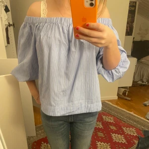 Blå randig offshoulder topp - Säljer en superfin blå randig offshoulder topp med trekvartsärmar! Har aldrig använt den💘