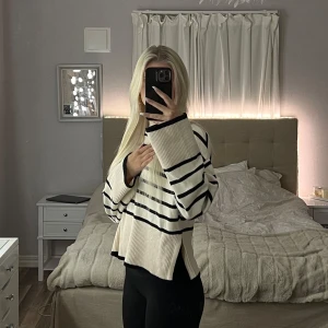 Randig tröja från Gina Tricot - Säljer en superfin randig tröja från Gina Tricot i storlek XS. Den är vit med svarta ränder och har en avslappnad passform. Perfekt för både höst och vår! Tröjan är i mycket bra skick och är gjord av mjukt material som känns skönt mot huden. Passar perfekt till ett par jeans eller leggings.