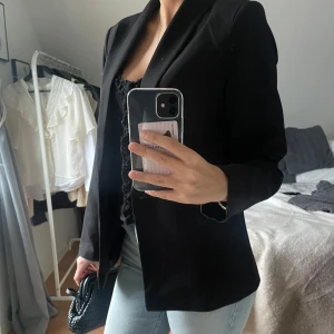 Svart kavaj - Snygg svart kavaj i klassisk stil. Perfekt för både vardag och fest. Den har en normal passform och långa ärmar. Den är knappt använd och i väldigt bra skick! 