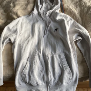 Vit hoodie från Nike - Säljer en vit hoodie från Nike med lite fläckar på sig annars inget fel på den.