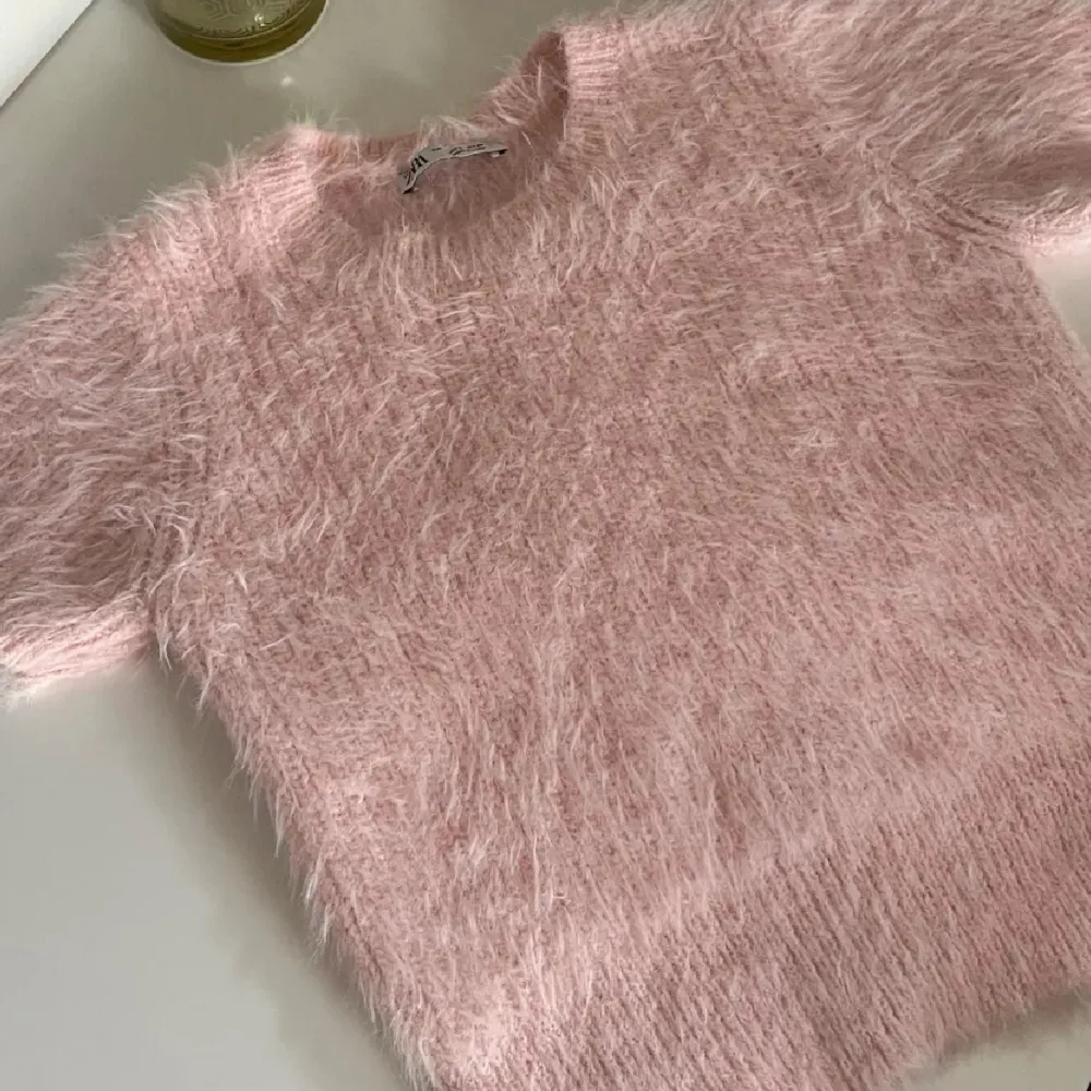 Supermjuk och fluffig rosa tröja från Zara som är perfekt för att mysa till det lite extra. Endast använd max två gånger. Den har korta ärmar och en härlig textur som gör den unik. Perfekt för både vardag och festliga tillfällen. 🩷. Tröjor & Koftor.