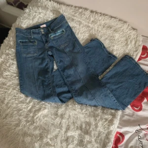 Blå jeans från Nelly - Fina Lågmidjade Bootcut jeans. Jeansen har fläckar där fram på byxornas fickor men är i ett fint skick. De är aldrig använda💕💕 