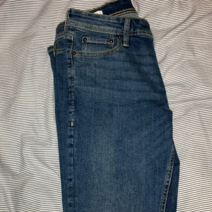 Blå jeans från Jack & Jones - Säljer ett par snygga blå jeans från Jack & Jones i modellen Slim Glenn och storleken 30 32. De har en slim passform och är i utmärkt skick. Perfekta för både vardag och fest