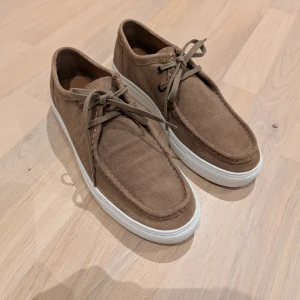 Bruna mockaskor med snörning från River Island stl 42 - Säljer ett par snygga bruna mockaskor, helt oanvända. Från River Island i stl 42.