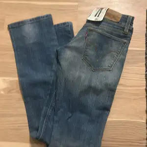 Säljer ett par klassiska Levi's 470 jeans i blå denim. De har en straight tapered passform och är i nytt skick med etiketten kvar. Perfekta för både vardag och fest! 👖