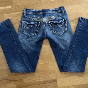 Lågmidjade jeans - Lågmidjade jeans stl:38 i bra skick. Har försvunnit några ”diamanter” från de på baksidan annars jättebra skick. Köpte de på plick för ca 1 år sedan, men har inte kommit till användning. De är klippta nertill för att göra de längre. 