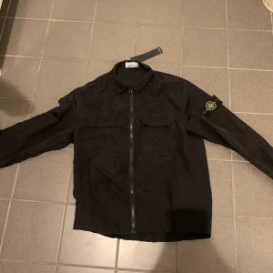Stone Island jacka  - Denna Stone Island jacka är helt ny och är aldrig använd. Denna passar perfekt att gå utt med på våren,sommaren, höst men kan också användas innomhus som kofta. Denna är väldigt snygg och bra skick.