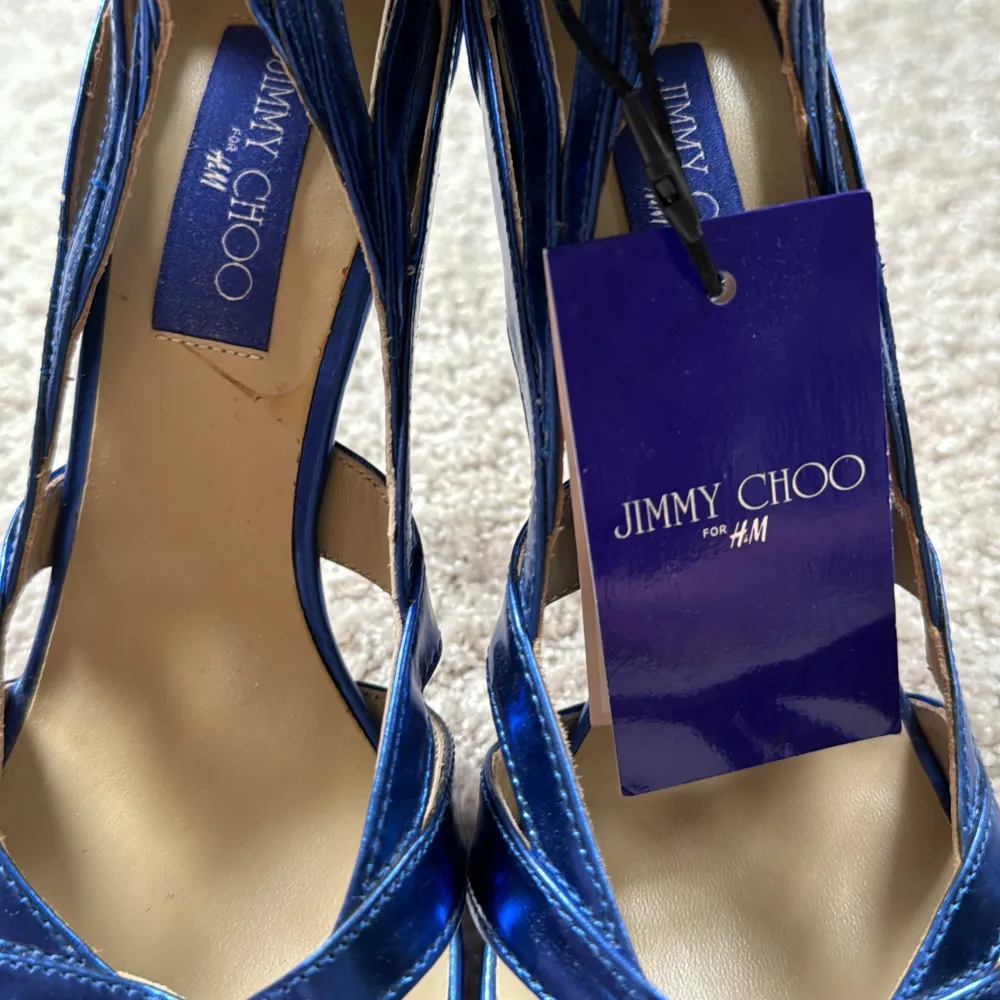 I unikt samarbete mellan Jimmy Choo och H&M säljer jag nu mina supersnygga, coola pumps. Aldrig använda. Lapparna är kvar. Stl 39. Fin mörkblå färg i metallic.. Skor.