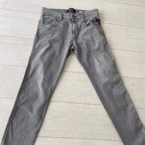Replay Anbass Grå - Tjena, Jag säljer nu mina gråa replay jeans då dem inte används. Byxorna är i väldigt bra skick och skulle ge dem 9/10 i skick. Dem är i storleken 31/32 och passar mig väldigt bra som är runt 180 och väger runt 70. 