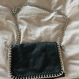 Väska med kedja - Jättefin väska med en silvrig kedja som axelband. Aldrig använt den själv! Nypris: 550kr