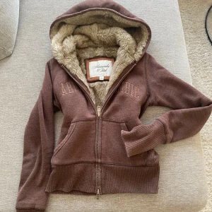 Abercrombie & fitch - Abercrombie & fitch hoodie med mjuk päls både på insidan och luvan  använd en gång och är i helt nyskick utan några som helst skador eller täcken står M men är mer S/xs