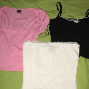 3 toppar för 300kr - Uppdatera gaderoben med dessa fina toppar! Vit tubtopp med prislapp (XS) från Bikbok ,ps har den även i S. Rosa croptop från Gina(Xs), aldrig använd. Svart korsettplagg från Gina(Xs), aldrig använd. Frakt tillkommer!