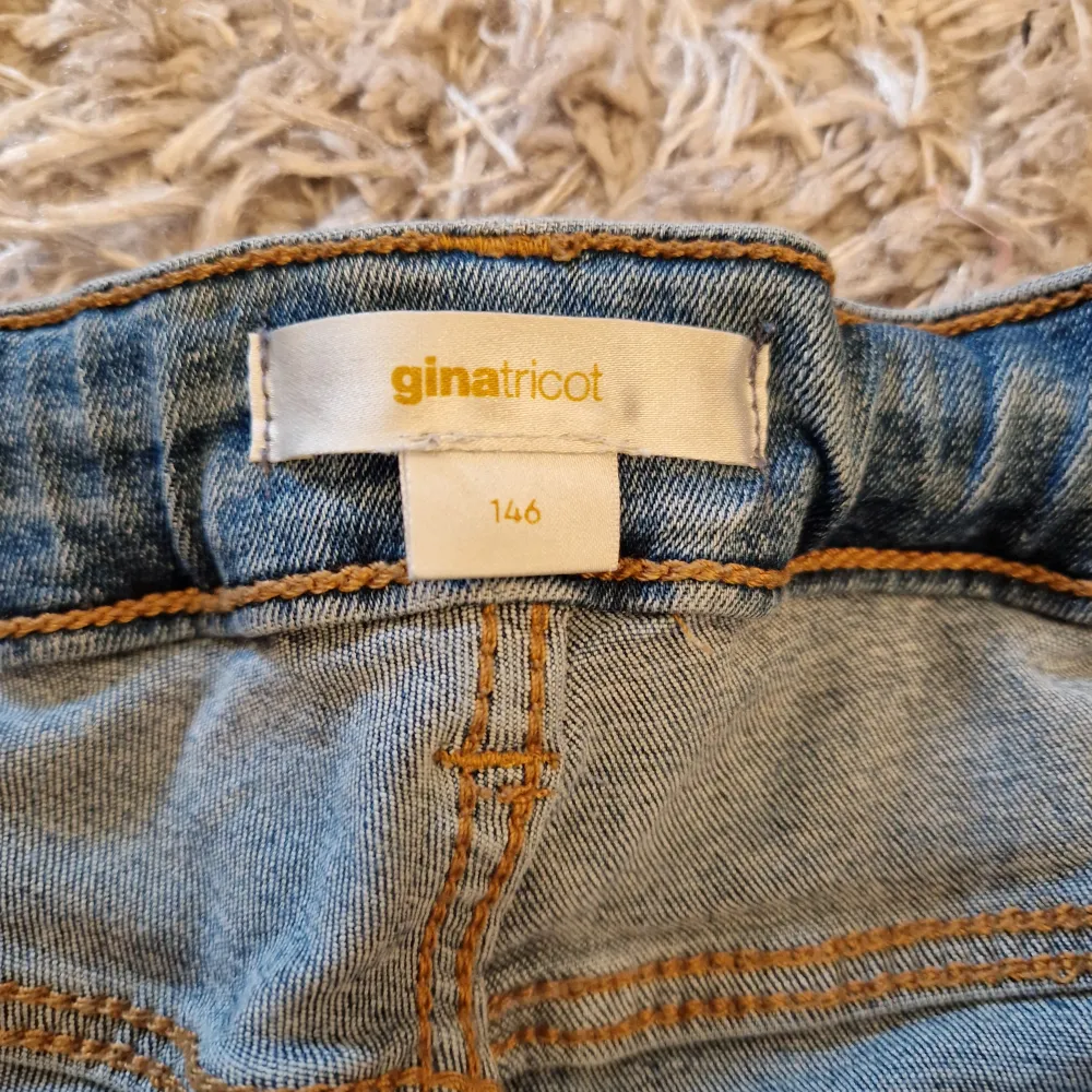 Säljer ett par snygga blå jeans från Gina Tricot i storlek 146. De har en klassisk femficksdesign med knappar bak och en bekväm passform. Perfekta för vardagsbruk och kan matchas med nästan vad som helst. De är i bra skick och redo för en ny ägare!. Jeans & Byxor.