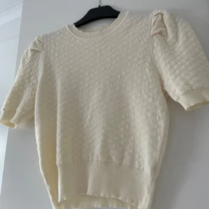 Krämfärgad stickad tröja från Knit Mix - Säljer en superfin krämfärgad stickad tröja från SHEIN. Den har ett diskret mönster och puffiga korta ärmar som ger en söt touch. Perfekt för både vår och höst! 🧡