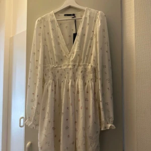 Klänning med blommor - Säljer denna fina klänning från Lager157 då den inte kommer till användning. Storlek S, lappen är kvar.
