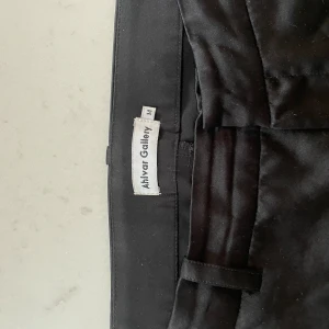 Svarta byxor från Alvar Gallery - Säljer ett par stilrena svarta byxor från Alvar Gallery. De är i storlek M och har en klassisk design med en rak passform. Perfekta för både vardag och festliga tillfällen!