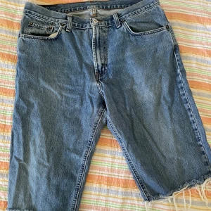 Blå jeansshorts från Mc Gordon - Säljer ett par klassiska blå jeansshorts från Mc Gordon. De har en avslappnad passform med råa kanter och är tillverkade i 100% bomull. Perfekta för en casual look i sommar!