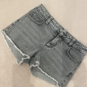 Gråa shorts med fickor där bak - Säljer dessa jättensygga jeans med fickor där bak, köpta på kids brand store, skriv för mått och prisförslag💕