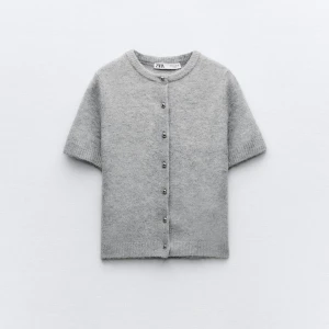 Grå kofta från Zara - Säljer en superfin grå kofta från Zara. Den är kortärmad och har snygga knappar framtill. Perfekt för både vår och höst när det är lite kyligt. Materialet känns mjukt och mysigt, perfekt för att hålla sig varm och stilren. Är i lika nytt skick som när den köptes! står inte för frakt.