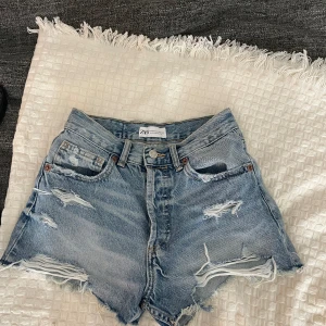 Zara jeansshorts - Ett par blåa jeansshorts med slitningar 