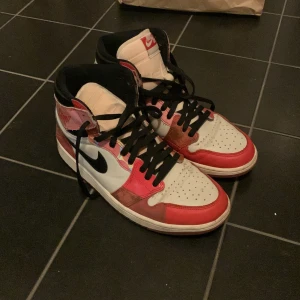 Nike Air Jordans i rött och vitt - Säljer ett par speciella spiderman Nike Air Jordans i rött och vitt. Skorna har en snygg design med svart snörning och den ikoniska Nike-loggan på sidan. Perfekta för både vardag och fest! dem lysser under skorna genom UV lampa eller sol!