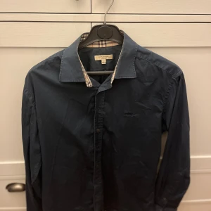 Burberry skjorta - Tja! Säljer nu dena sällsynta mörkblå burberry skjorta i strolek L men den är ganska liten i strolek så passar M. Skjortan är i väldigt bra skick. Skriv om du har någon fråga eller fundering!👊