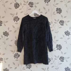 Svart långärmad oversize tröja eller klänning från Cubus, Strl: S/36 - Säljer en svart långärmad tröja/klänning från Cubus i storlek S. Tröjan är tillverkad av en mjuk blandning av akryl och nylon, perfekt för kyligare dagar. Enkel och stilren design som passar till många tillfällen.