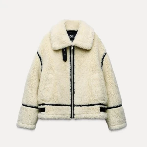 Vit teddyjacka från Zara - Säljer en mysig vit teddyjacka från Zara med svarta detaljer och dragkedja. Nästan aldrig använd och sälj därför. Nypris 1195 kr. Skriv för fler bilder. 