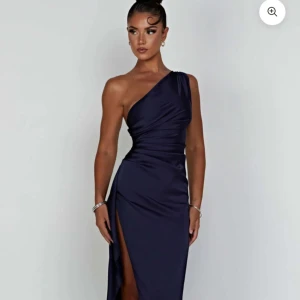 Mörkblå oneshoulder klänning - Elegant mörkblå klänning med oneshoulder-design och en stilfull slits. Perfekt för festliga tillfällen. Och speciellt bal 