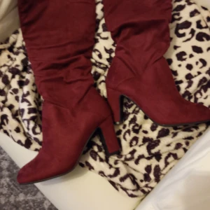 Röd stövel mocka immitation stl 39 klack 8 cm hög. - Helt nya och oanvända stövlar röda mocka immitation stl 39 klack 8 cm hög. Något smal fot.