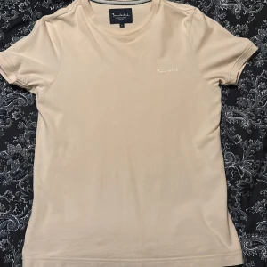 T-shirt från Bondelid - Säljer en stilren beige t-shirt från Bondelid. Den har en klassisk design med rund hals och korta ärmar. Perfekt för en avslappnad look. Riktigt fint skick på den. Säljer den nu för att den har blivit för liten. Hör av er vid frågor 🤩