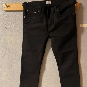 Svarta jeansbyxor - Snygga svarta jeansbyxor med en klassisk femficksdesign. De har en dragkedja och knapp framtill. Perfekta för en stilren look.