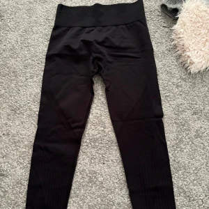 Svarta leggings - Snygga svarta leggings med hög midja och ribbade detaljer. Perfekta för både träning och vardag. Aldrig använda!