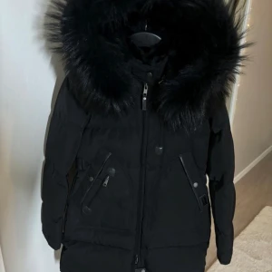 Cedrico Monet XXS - Säljer min Cerico Monet black fade jacka med äkta svart päls i storlek XXS men passar även XS, helt ny med lappar kvar. Nypris 8.499kr, finns även kvitto. Finns att hämta i Rissne eller få den skickad via Plick. Priset kan diskuteras vid snabb affär.