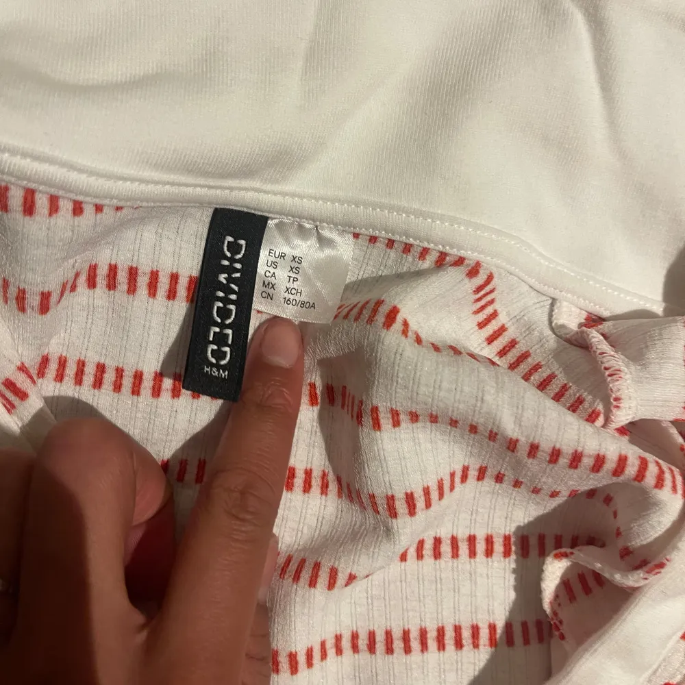 Säljer en söt vit och röd randig klänning från H&M. Klänningen har en v-ringad hals och korta ärmar, perfekt för en avslappnad stil. Materialet är mjukt och bekvämt. Till julen 😍😍. Mekot.