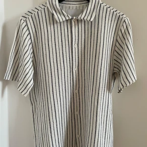 Svart- och vitrandig kortärmad skjorta från Lager 157 - Svart- och vitrandig kortärmad skjorta från Lager 157 i storlek S. Nyskick, prislappen sitter kvar på plagget!