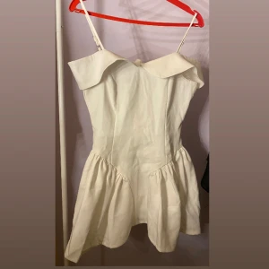 Vit klänning från Boohoo - Säljer en söt vit klänning från Boohoo med axelbandslös design och volangdetaljer. Klänningen har en kort längd och är perfekt för sommarens festligheter. Den har en luftig passform och justerbara axelband. Går att snacka om pris. 