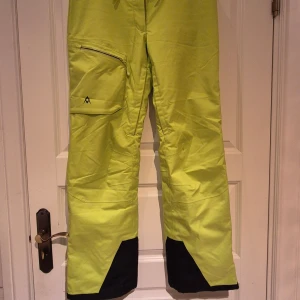 Gul/gröna  skidbyxor från Volkl strl 38 - Säljer ett par coola gröns skidbyxor från Volkl. Byxorna har fickor med dragkedjor, justerbar midja, snölås och dragkedja nertill. Sparsamt använda. 