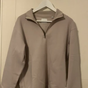 Beige Jack And Jones half zip - Säljer en stilren beige tröja med halv zip. Perfekt för en avslappnad look. Tröjan har långa ärmar och är gjord i ett mjukt material. Tröjan är aldrig använd och i ett perfekt skick. Kom privat för fler bilder eller andra funderingar 